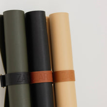 Charger l'image dans la galerie, Rouleaux de tapis de rempotage en cuir olive, noir et beige, sangles brunes.