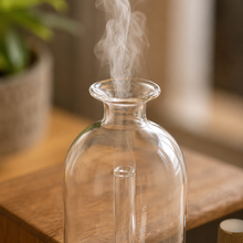 Charger l'image dans la galerie, Vapeur sortant du diffuseur en verre transparent, goulot large sur planche bois
