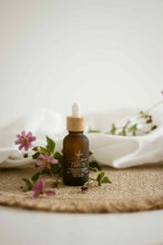 Load image into Gallery viewer, Flacon d’huile essentielle ZARIS ambré avec pipette et fleurs roses sur tissu

