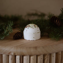 Load image into Gallery viewer, Boule de bain effervescente blanche à points verts, sur un support en bois
