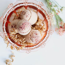 Load image into Gallery viewer, Boule de bain effervescente avec pétales, dans l’eau, tons rosés

