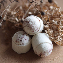 Load image into Gallery viewer, Boules de bain effervescentes blanches avec touches rouges, sur support beige
